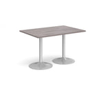 A rectangular table with a grey wood-effect top and two silver pedestal bases, shown on a plain white background.