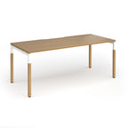 Straight desk with light oak wood grain top and legs with white frame on a white background