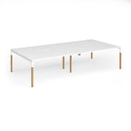 Double back to back desk with white top and wooden legs on a white background