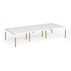 Triple back to back desk with white top and wooden legs on a white background