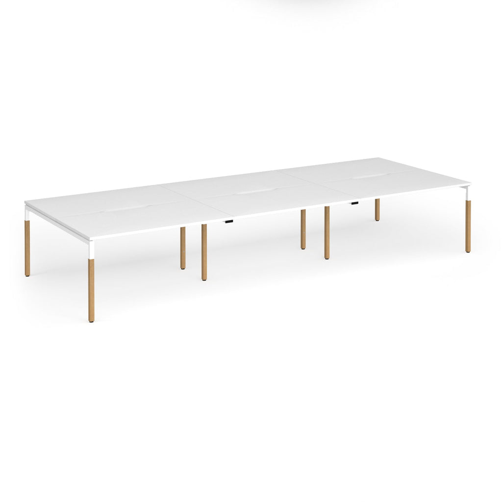 Triple back to back desk with white top and wooden legs on a white background