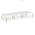 Triple back to back desk with white top and wooden legs on a white background