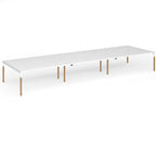 Triple back to back desk with white top and wooden legs on a white background