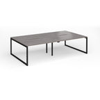 Back-to-back bench desk with grey wood-effect top and black metal legs on a white background