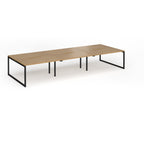 Long back-to-back desk with wood-effect top and black metal legs on a white background