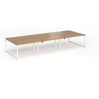 Long back-to-back desk with wood-effect top and white metal legs on a white background
