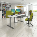 Modern office setup with a standing desk, green chair, and computer setup.