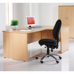 Wooden office desk with a chair, computer, and plant in a bright room.