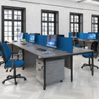 Modern office setup with desks, chairs, and computer monitors in a well-lit room.