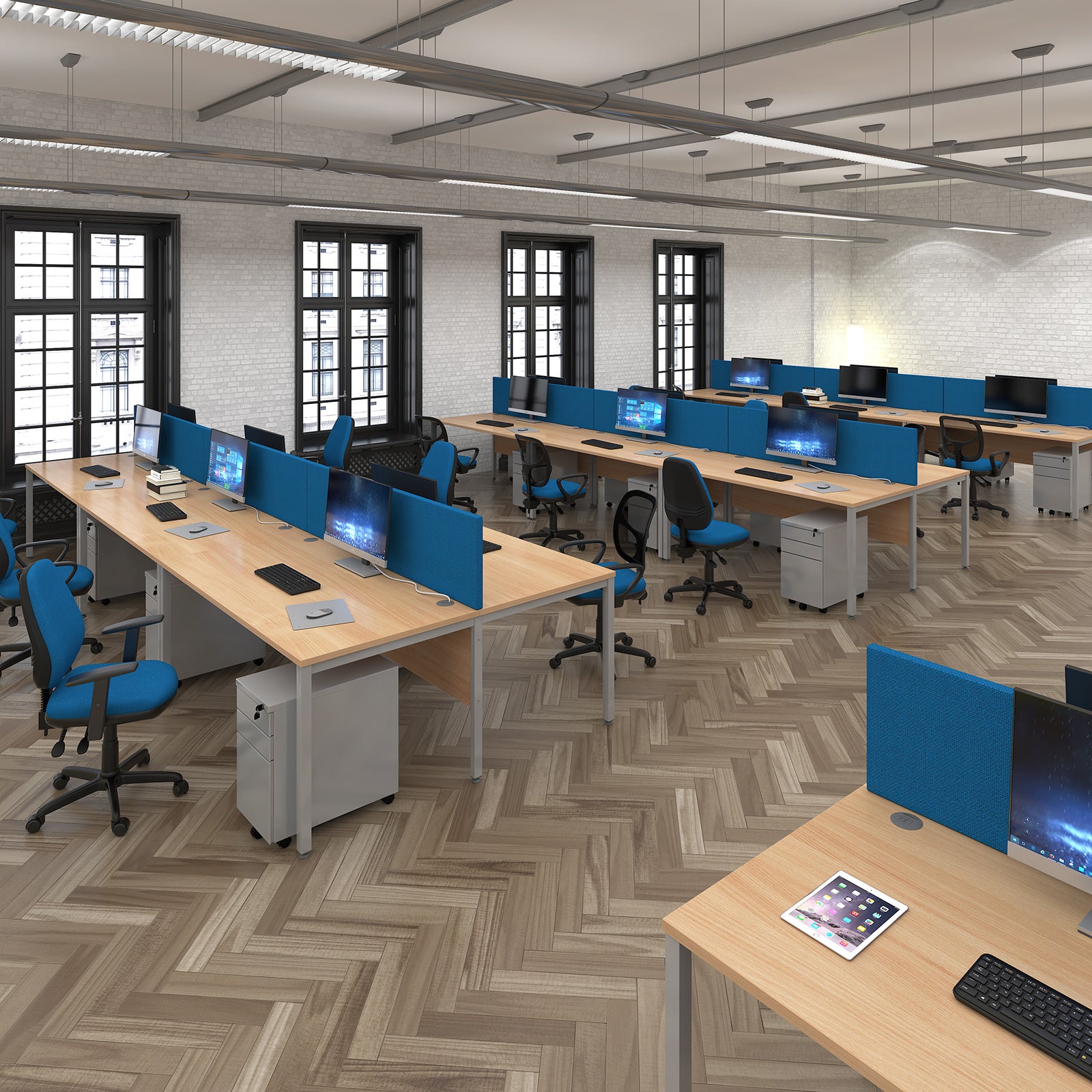 Modern office with wooden desks, blue chairs, and computer monitors arranged in a grid layout.