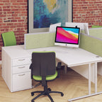 Modern office desk setup with a computer, chair, and green partition against a brick wall.