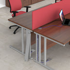 Office setting with desks, red chair and screen and laptop