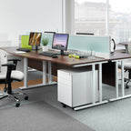 Modern office desk setup with multiple monitors, chairs, and a filing cabinet.