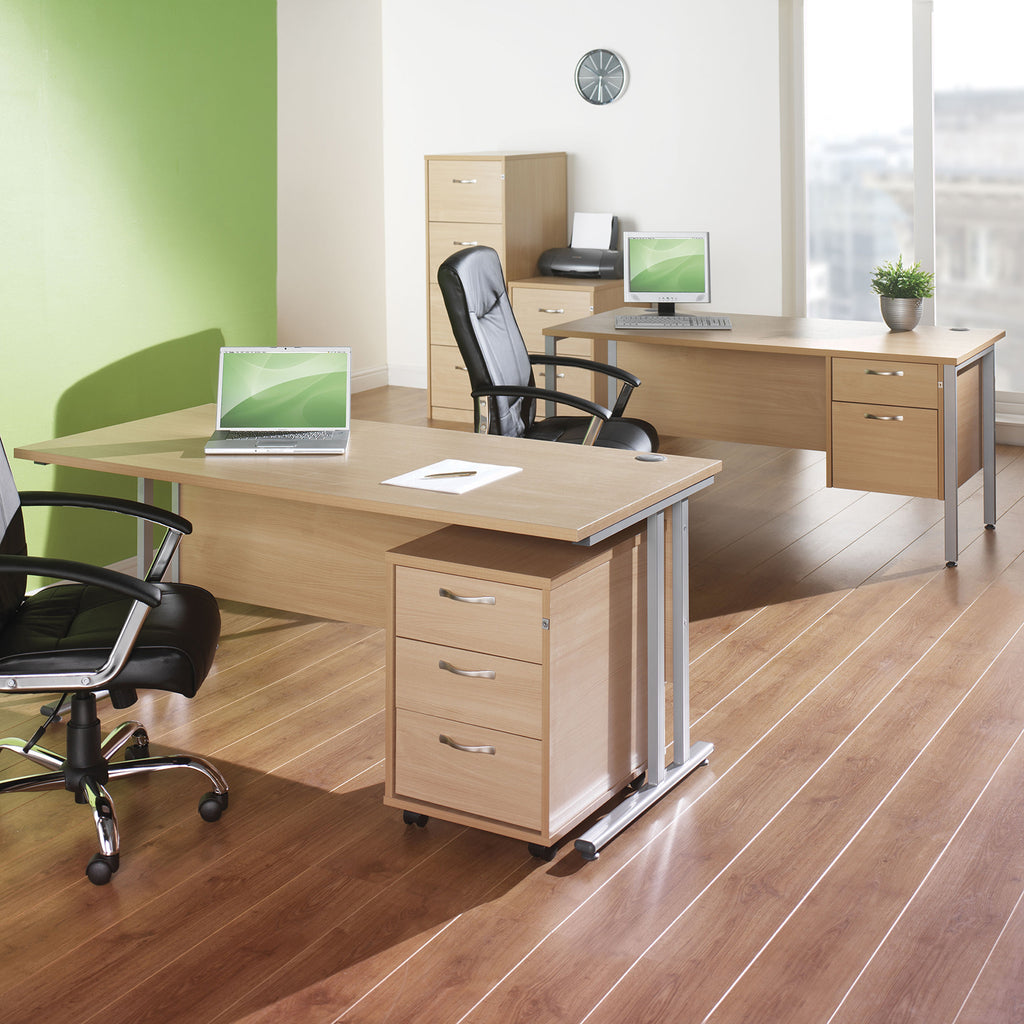 Modern office setup with wooden desks, chairs, and computer equipment.