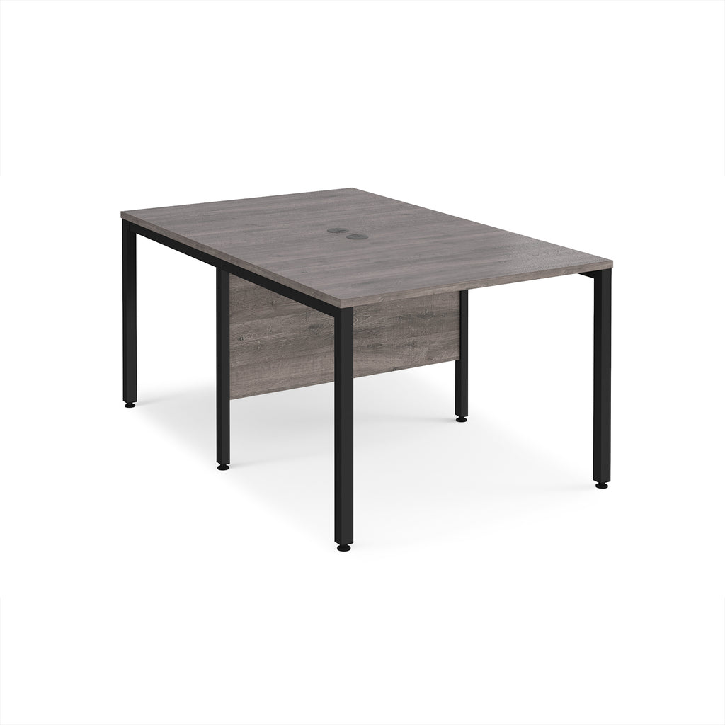 Back-to-back office desk with grey wood-effect top and black metal frame on a white background