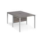 Back-to-back office desk with grey wood-effect top and silver metal frame on a white background