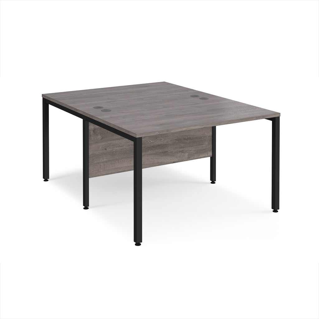 Back-to-back office desk with grey wood-effect top and black metal frame on a white background