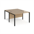 Back-to-back office desk with wood-effect top and black metal frame on a white background