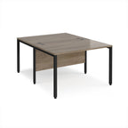 Back-to-back office desk with wood-effect top and black metal frame on a white background