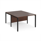 Back-to-back office desk with wood-effect top and black metal frame on a white background
