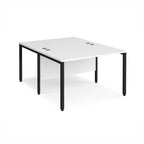 Back-to-back office desk with white top and black metal frame on a white background
