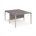Back-to-back office desk with grey wood-effect top and silver metal frame on a white background