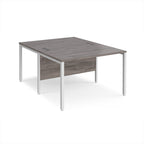 Back-to-back office desk with grey wood-effect top and white metal frame on a white background