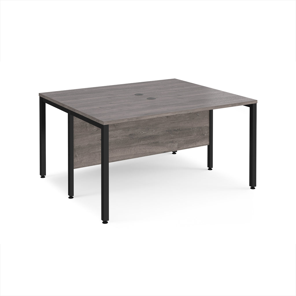 Back-to-back desk with grey wood-effect top and black metal frame on a white background