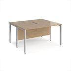 Back-to-back desk with wood-effect top and silver metal frame on a white background