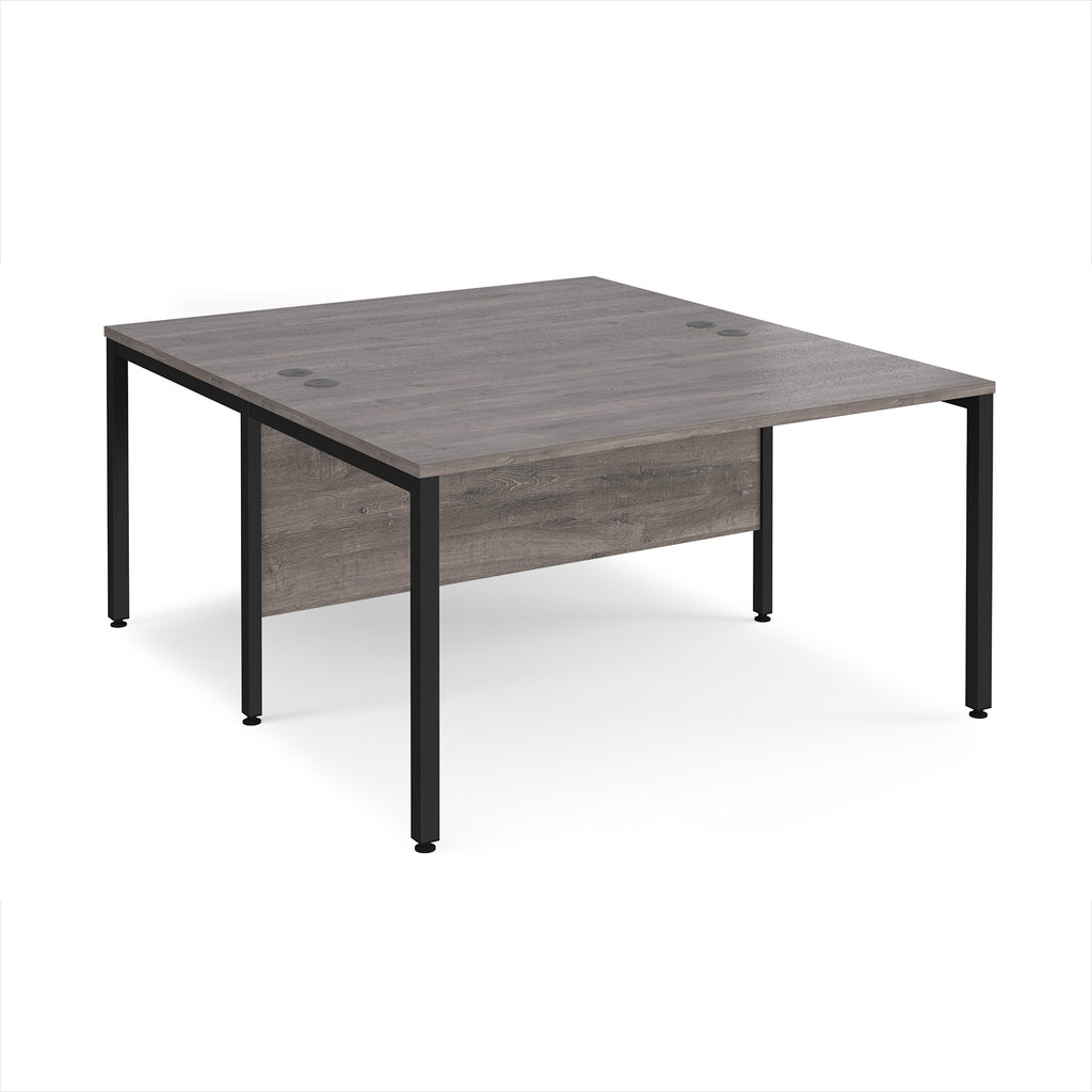 Back-to-back office desk with grey wood-effect top and black metal frame on a white background