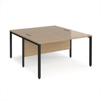 Back-to-back office desk with wood-effect top and black metal frame on a white background