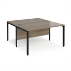 Back-to-back office desk with wood-effect top and black metal frame on a white background
