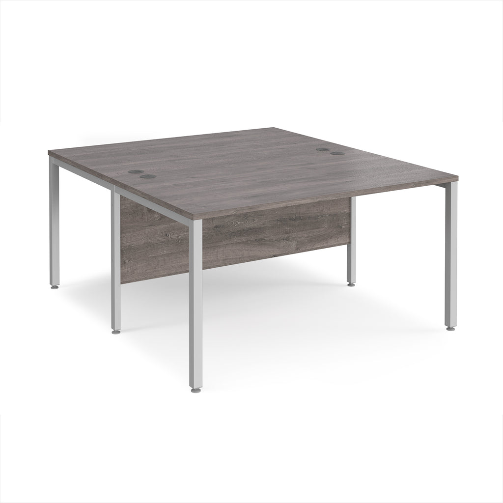Back-to-back office desk with grey wood-effect top and silver metal frame on a white background