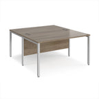 Back-to-back office desk with wood-effect top and silver metal frame on a white background