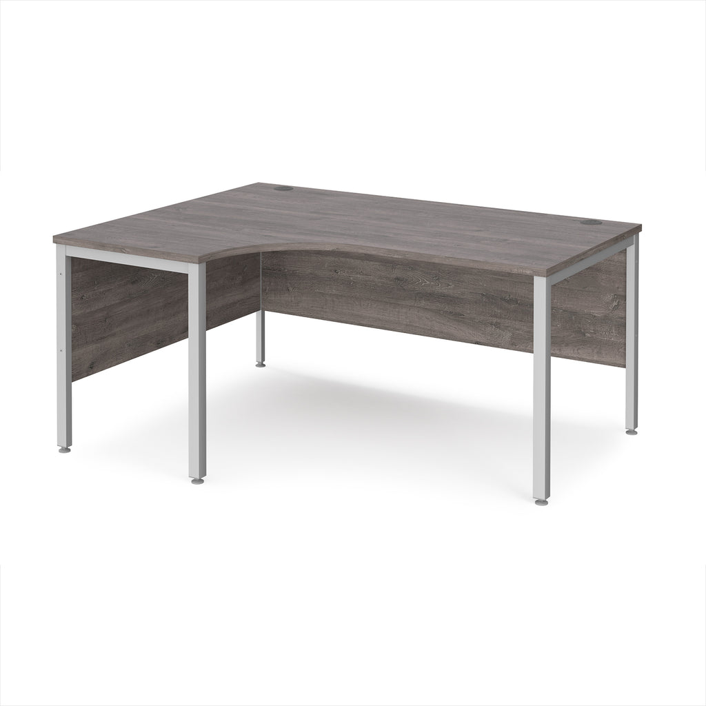 Ergonomic office desk with grey wood-effect top and silver metal frame on a white background