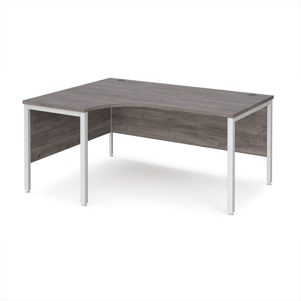 Ergonomic office desk with grey wood-effect top and white metal frame on a white background
