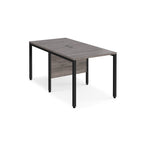 Back-to-back office desk with grey wood-effect top and black metal frame on a white background
