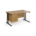Wooden office desk with black metal legs and three drawers on a white background