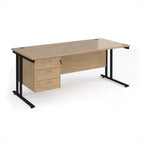 Wooden office desk with black metal legs and three drawers on a white background