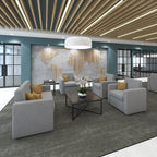 Modern office lounge with gray sofas, a coffee table, and decorative elements.