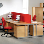 Modern office setup with wooden desks, red chairs, and computer monitors.