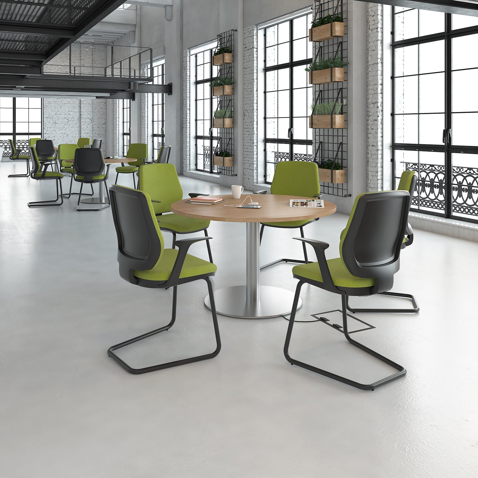 Modern office chairs with green seats and black frames around a round table in a bright room.