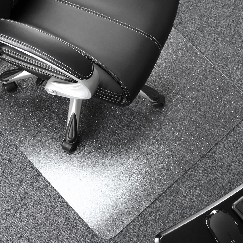 Black office chair with a transparent desk mat on a grey floor