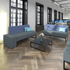 Modern office space with blue sofas, coffee table, and computer monitors.