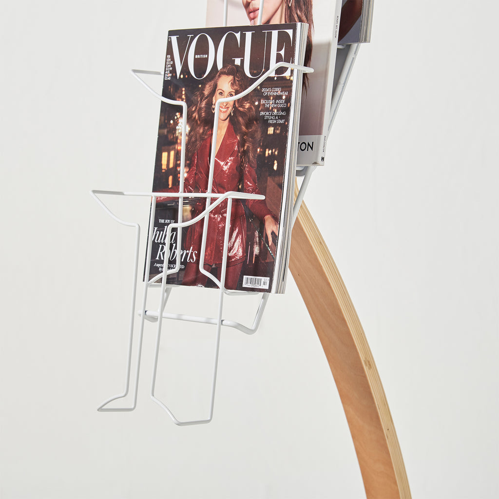 Magazine stand with 'Vogue' magazine on a white background