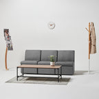 Gray sofa with wooden coffee table in a minimalistic living room setting.