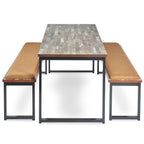 Industrial-style dining table with a reclaimed wood-effect top and black metal frame, paired with two matching bench seats with cushioned upholstery, shown on a white background.