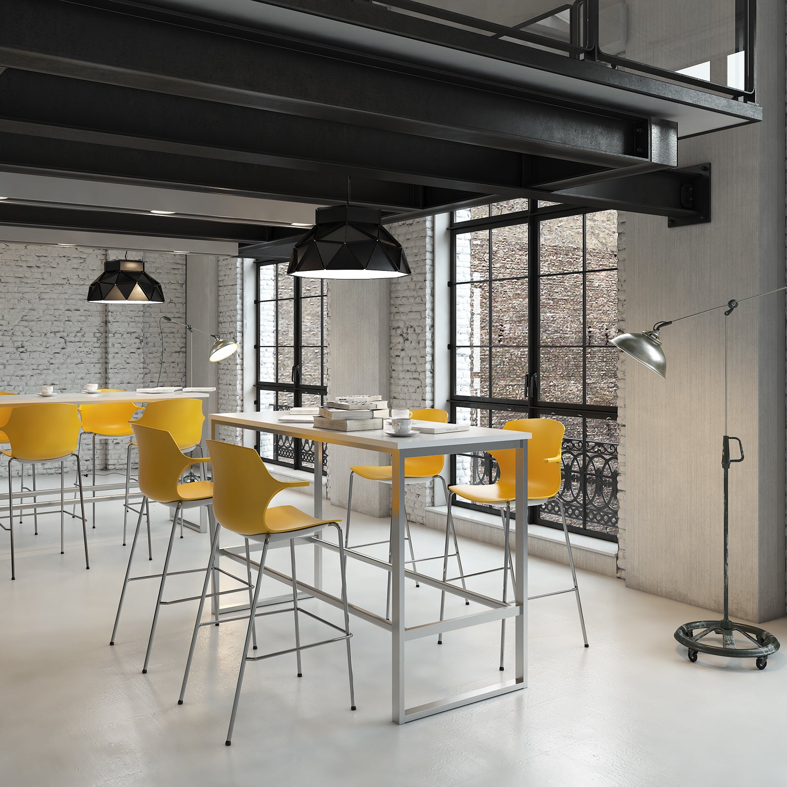 High table with a light grey top and metal frame, paired with yellow bar stools, shown in an industrial-style breakout and collaboration space.