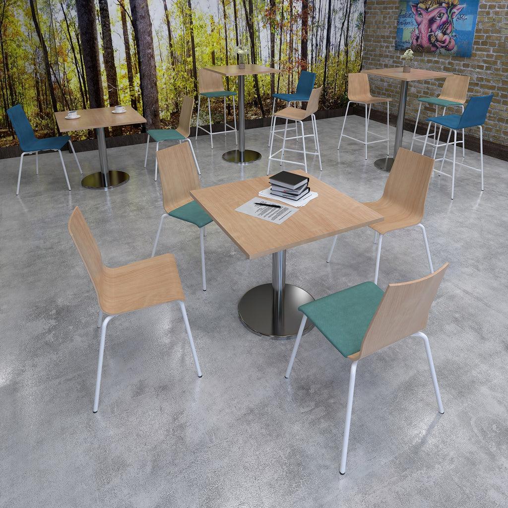 Modern cafe interior with tables and chairs against a forest mural.