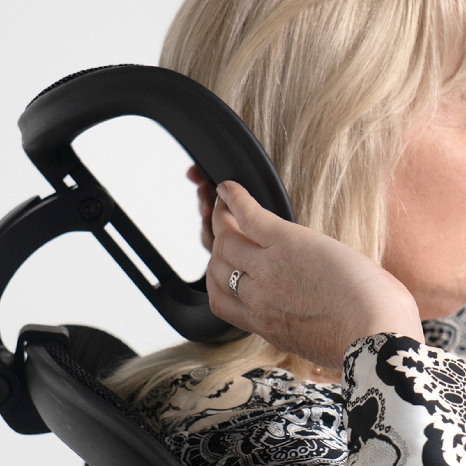 Person using a black office chair with a blurred background